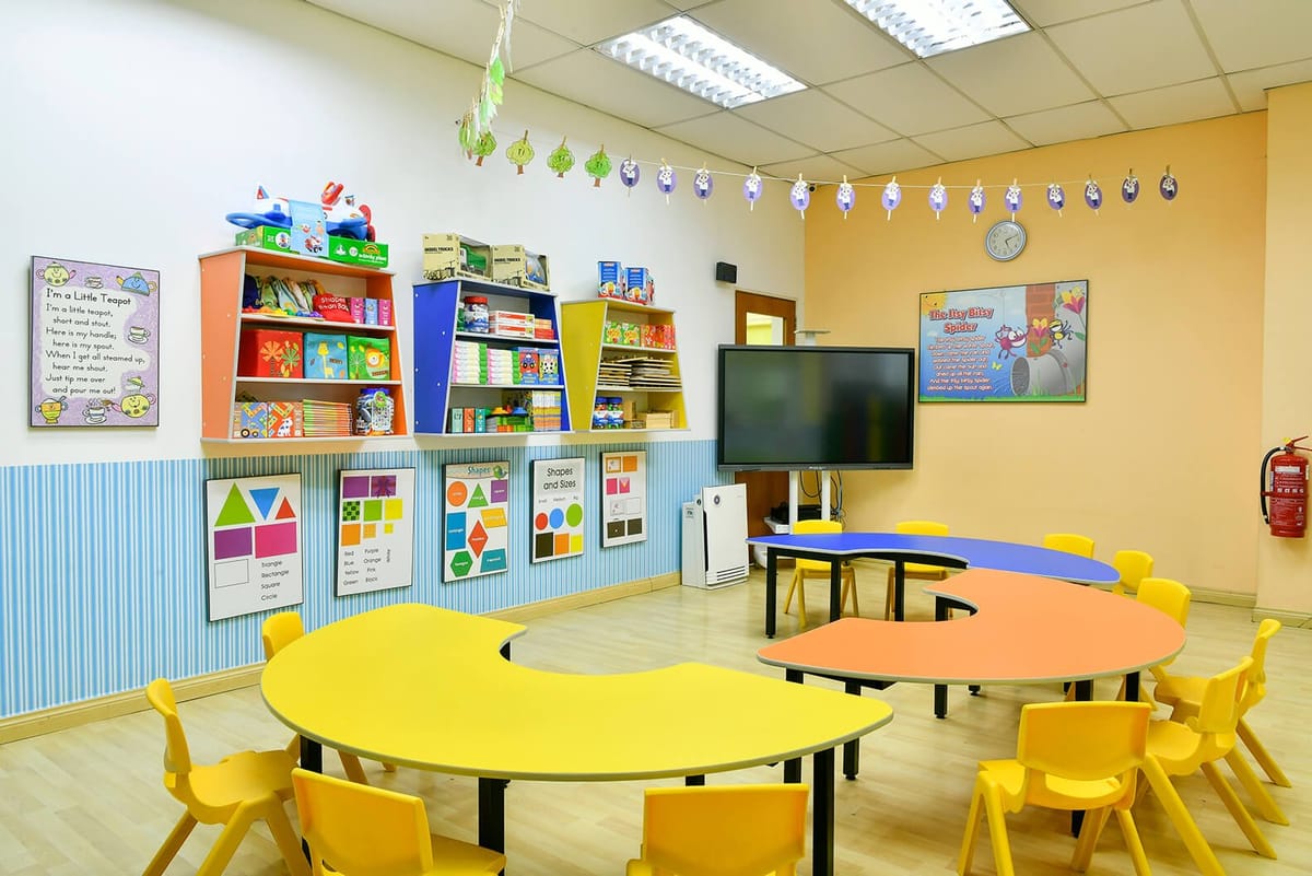 A kindergarten classroom with yellow tables
